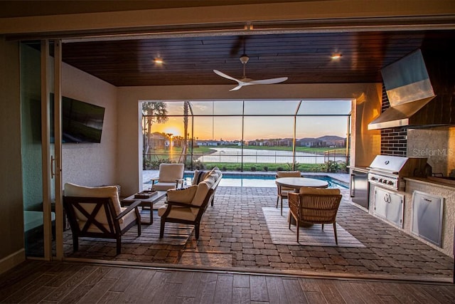 view of patio with grilling area, an outdoor kitchen, a lanai, and an outdoor pool