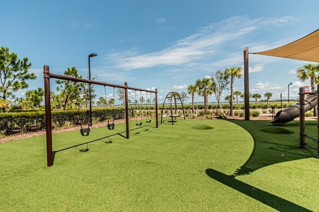 community play area with fence and a yard