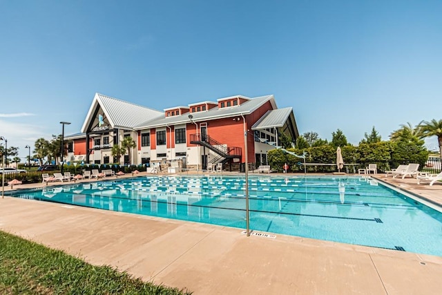 community pool featuring fence and a patio