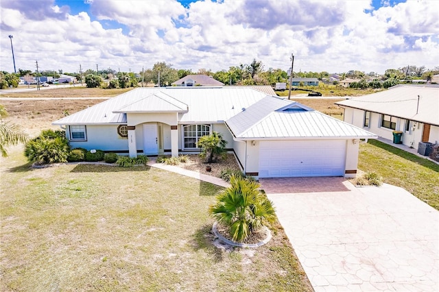 ranch-style house with a garage, central AC, metal roof, and decorative driveway