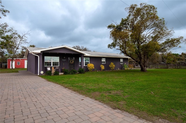 ranch-style home with stucco siding, decorative driveway, and a front yard