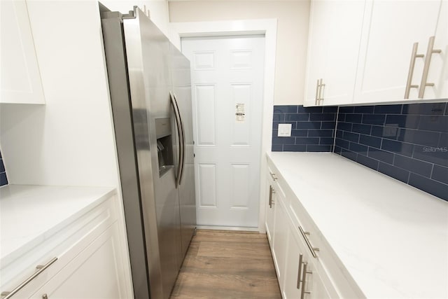 kitchen featuring white cabinetry, decorative backsplash, wood finished floors, and stainless steel fridge with ice dispenser