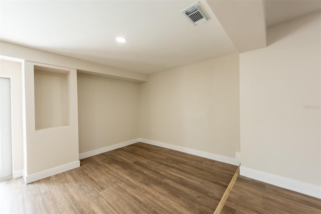 spare room with recessed lighting, visible vents, baseboards, and wood finished floors