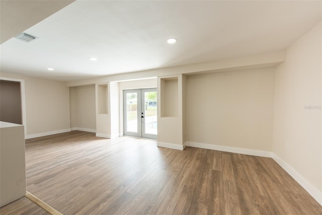 spare room featuring recessed lighting, wood finished floors, visible vents, baseboards, and french doors