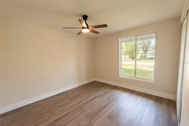 unfurnished room with ceiling fan, baseboards, and dark wood finished floors