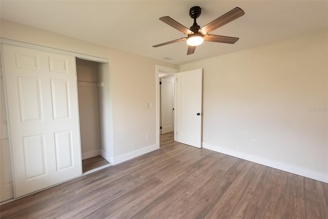 unfurnished bedroom with visible vents, baseboards, a ceiling fan, wood finished floors, and a closet