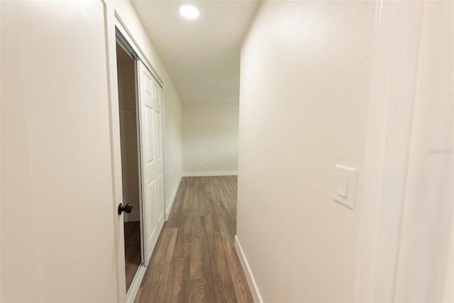 hall featuring baseboards, dark wood-style flooring, and recessed lighting