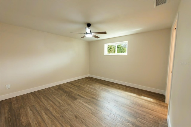 empty room featuring visible vents, baseboards, ceiling fan, and dark wood-style flooring