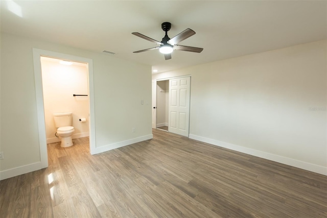 unfurnished bedroom with a closet, wood finished floors, visible vents, and baseboards