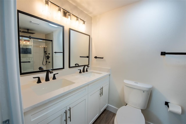 bathroom featuring a sink, a shower stall, and toilet