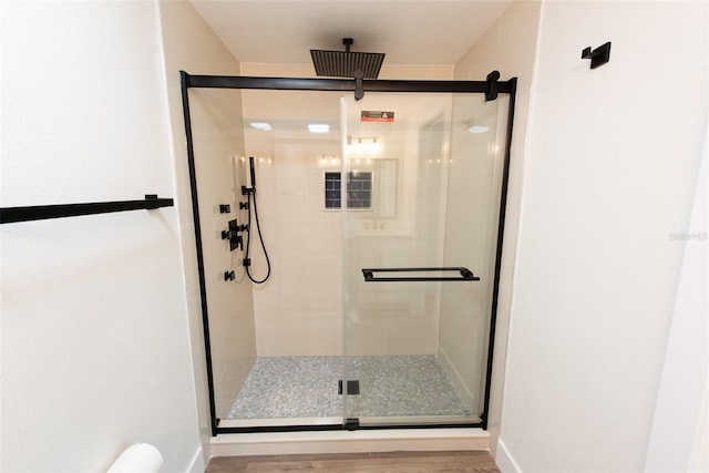 bathroom with a shower stall and baseboards