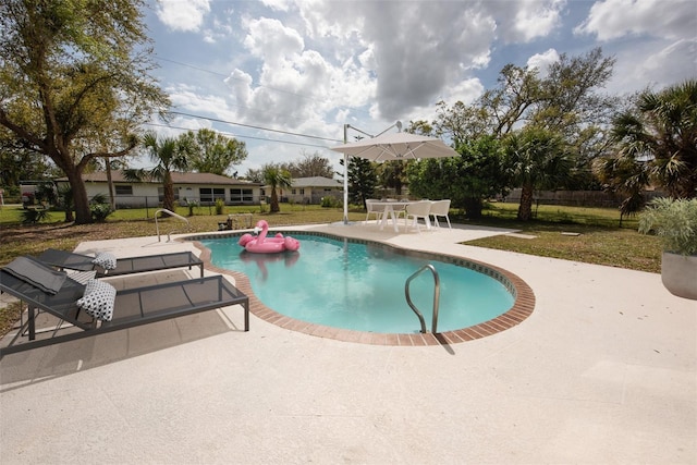 outdoor pool featuring a patio area, fence, and a yard