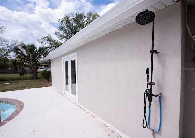 view of home's exterior featuring stucco siding and french doors