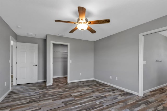 unfurnished bedroom featuring visible vents, a closet, baseboards, and wood finished floors