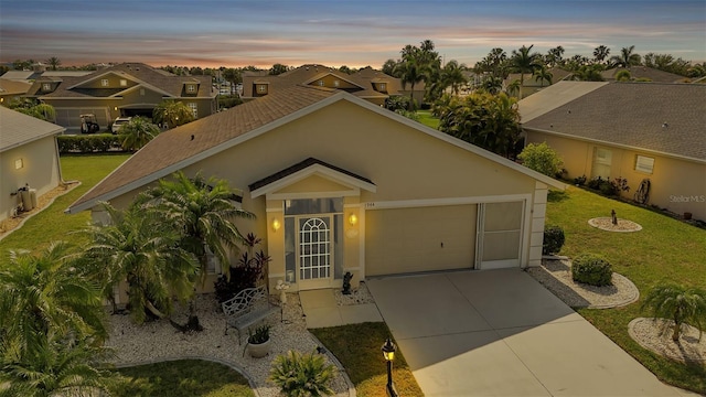 view of front of house featuring a garage, a residential view, concrete driveway, and stucco siding