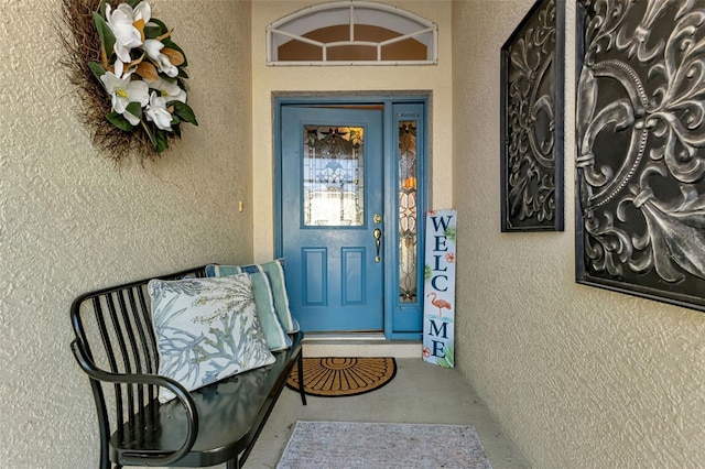 doorway to property featuring stucco siding