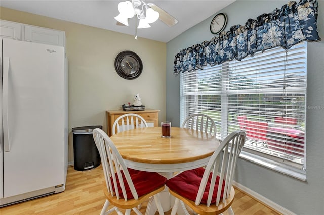 dining area with light wood-type flooring, ceiling fan, and baseboards