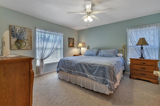 bedroom with a ceiling fan, light carpet, and baseboards