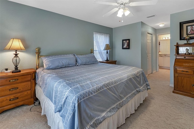 bedroom featuring light carpet, visible vents, a ceiling fan, ensuite bathroom, and a closet