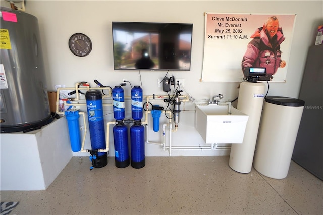 utility room with water heater and a sink