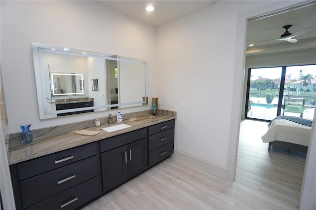 bathroom with ceiling fan, connected bathroom, recessed lighting, wood finished floors, and vanity