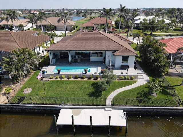 back of house featuring a water view, a patio area, a fenced backyard, and a yard