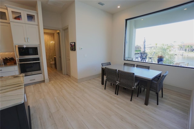 dining area with light wood-style floors, baseboards, visible vents, and recessed lighting