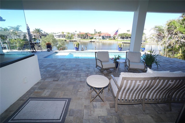 outdoor pool with a water view and a patio