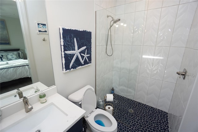 bathroom with tiled shower, vanity, toilet, and connected bathroom