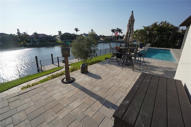 view of patio / terrace featuring a water view, fence, and a fenced in pool