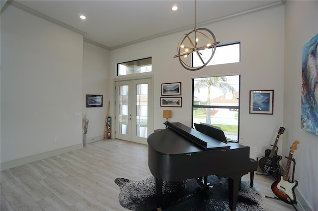 sitting room with ornamental molding, light wood-type flooring, french doors, and plenty of natural light