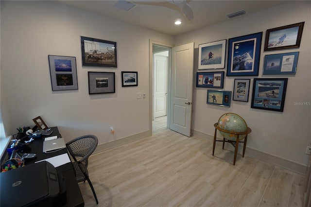 home office with a ceiling fan, light wood-type flooring, visible vents, and baseboards