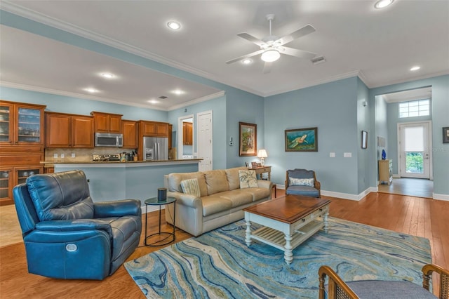 living area with crown molding, recessed lighting, visible vents, light wood-style floors, and baseboards