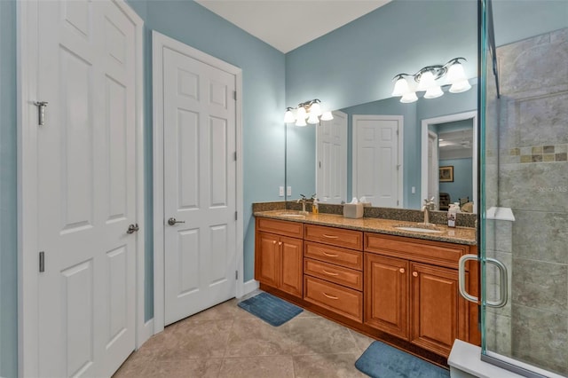 bathroom featuring a tile shower, double vanity, a sink, and tile patterned floors