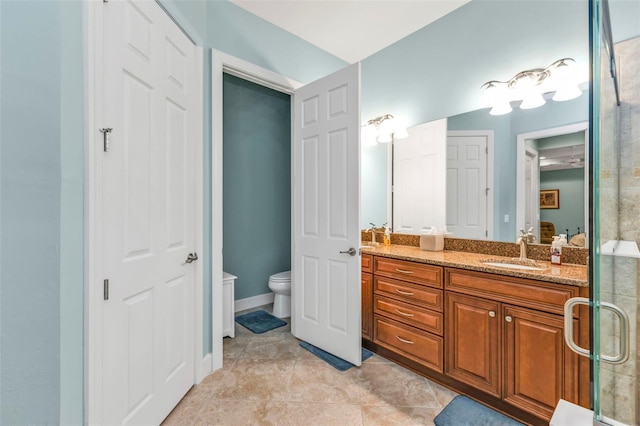 bathroom featuring double vanity, toilet, tile patterned floors, a shower stall, and a sink