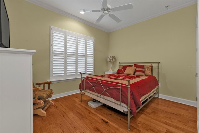 bedroom featuring a ceiling fan, baseboards, ornamental molding, and wood finished floors