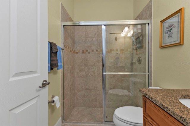 full bathroom featuring toilet, a shower stall, and vanity