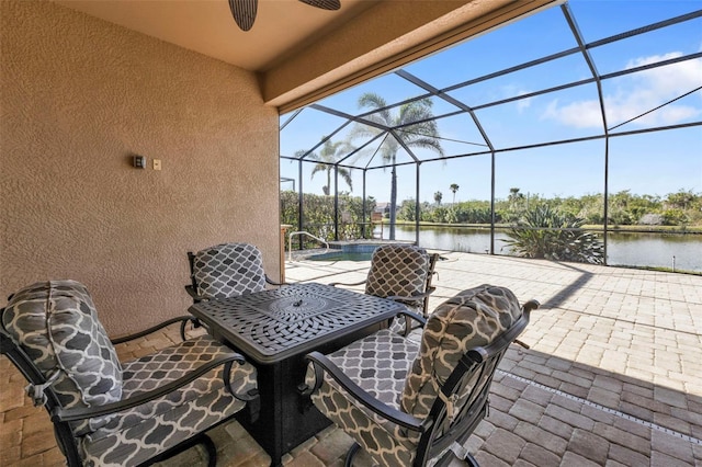 view of patio with a lanai and a water view