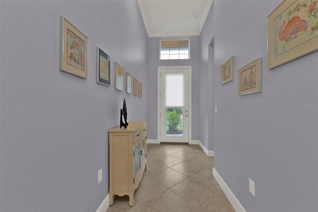 doorway with crown molding, baseboards, and a wealth of natural light