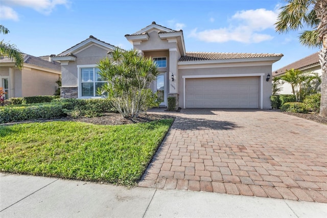 mediterranean / spanish-style home with a tiled roof, decorative driveway, an attached garage, and stucco siding