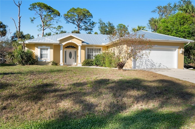 single story home with a garage, driveway, metal roof, a front lawn, and stucco siding