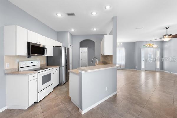 kitchen featuring appliances with stainless steel finishes, open floor plan, light countertops, and visible vents