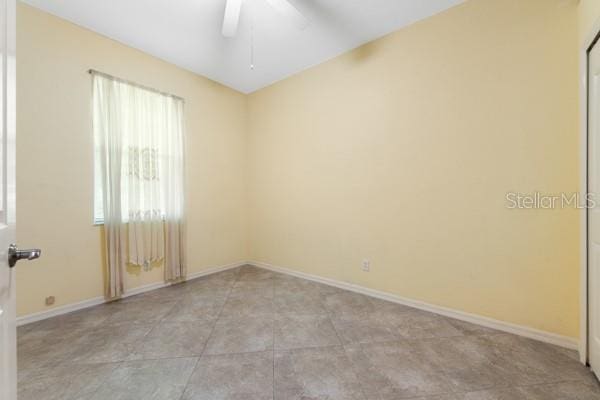 spare room featuring baseboards and a ceiling fan