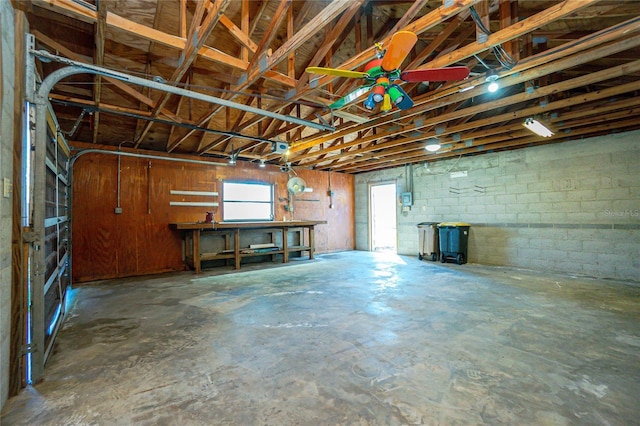 garage featuring concrete block wall and ceiling fan