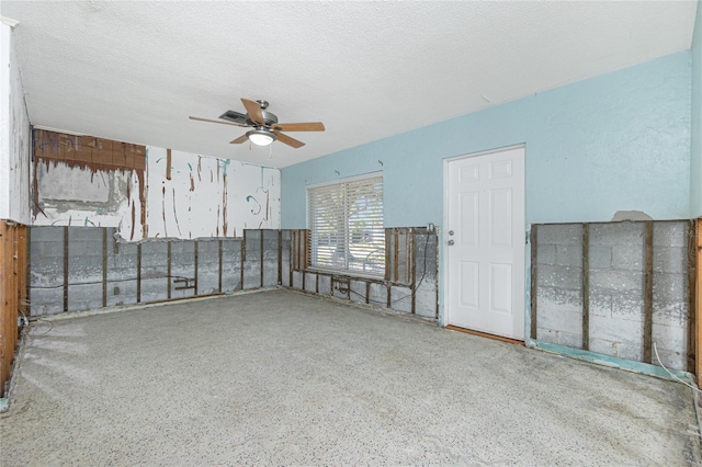 spare room with ceiling fan, a textured ceiling, and speckled floor