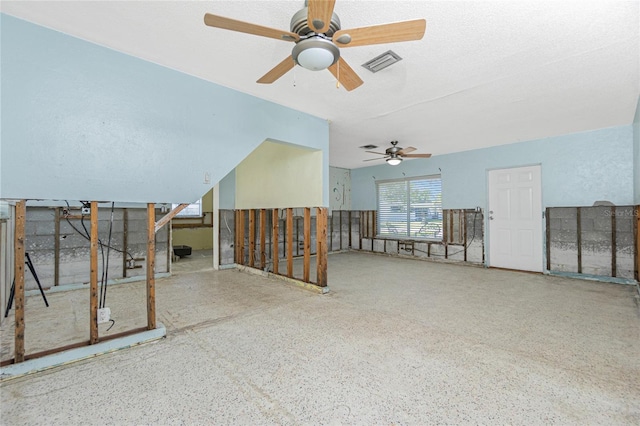 empty room with visible vents, a textured ceiling, and speckled floor