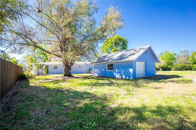 view of yard with an outbuilding, a detached garage, and fence