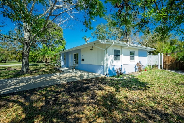 view of side of home with fence and a lawn