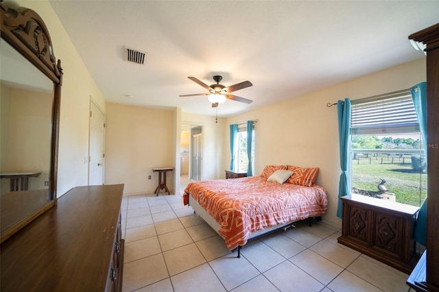 bedroom with a barn door, multiple windows, visible vents, and light tile patterned flooring