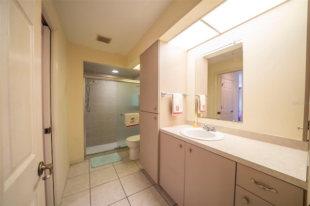 bathroom featuring toilet, vanity, visible vents, a shower stall, and tile patterned floors